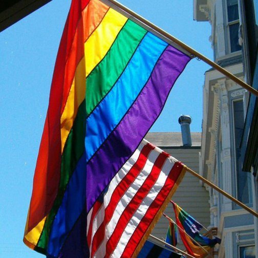 A rainbow flag beside an American flag
